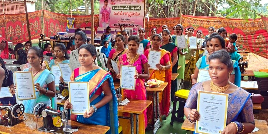 Rural women receiving tailoring course completion certificates